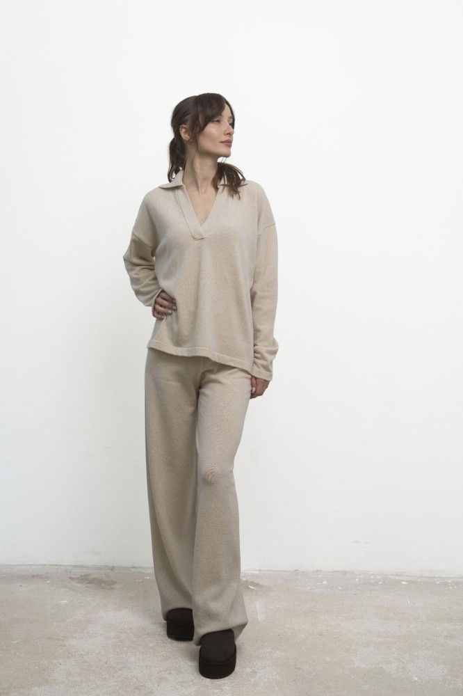 Sweter Lorenza Beige – beżowy sweter damski, przodem, modelka odwraca głowę w bok, beżowe spodnie