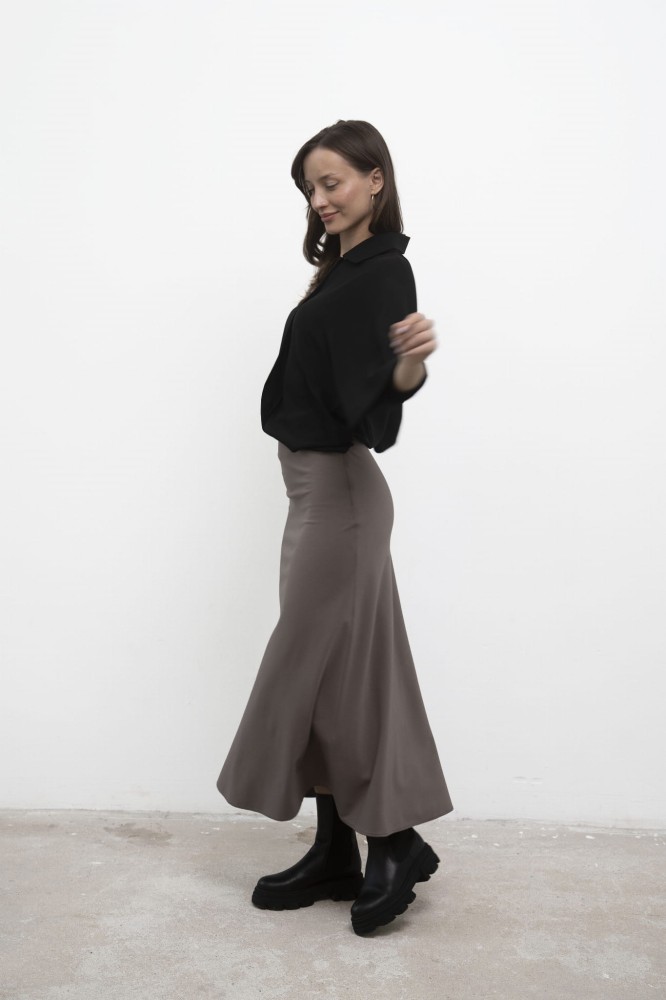 Spódnica Grace Beige midi, czarna koszula, ujęcie bokiem w ruchu.