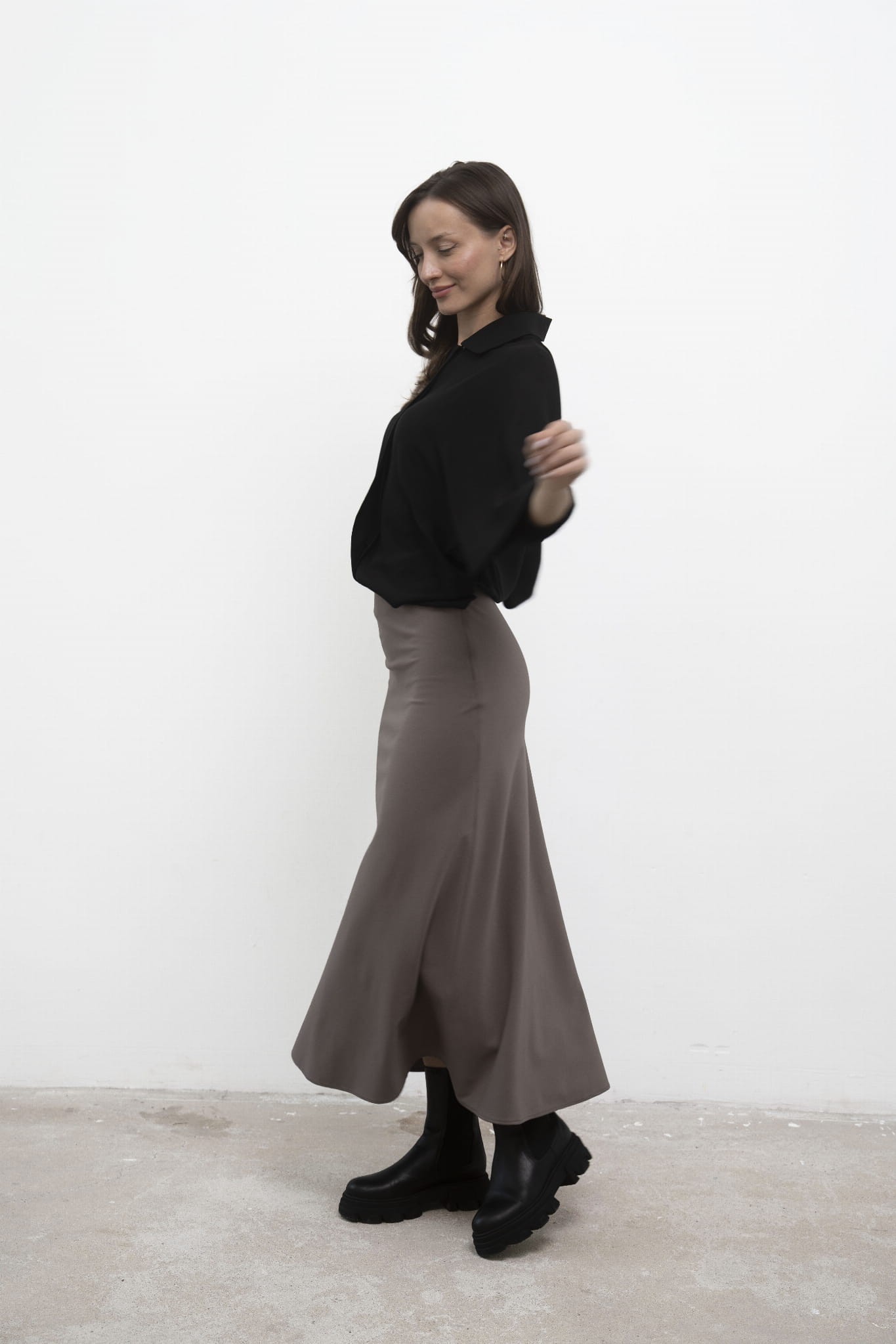 Spódnica Grace Beige midi, czarna koszula, ujęcie bokiem w ruchu.