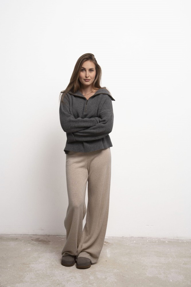 Spodnie Lorenza Petite Beige – beżowe spodnie damskie, modelka przodem w szarym swetrze, pełna sylwetka